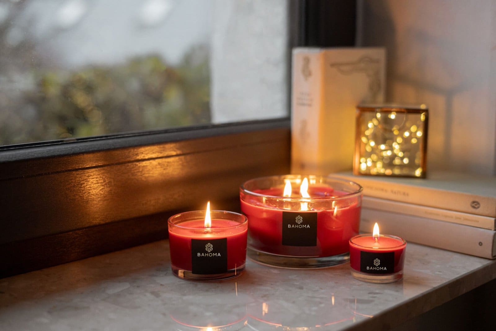 Bahoma red 3-wick Christmas candle on windowsill – warm festive ambience
